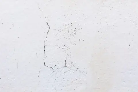 Pęknięcia na białym tynku, które mogą być odpowiedzią na pytanie dlaczego tynk gipsowy pęka.